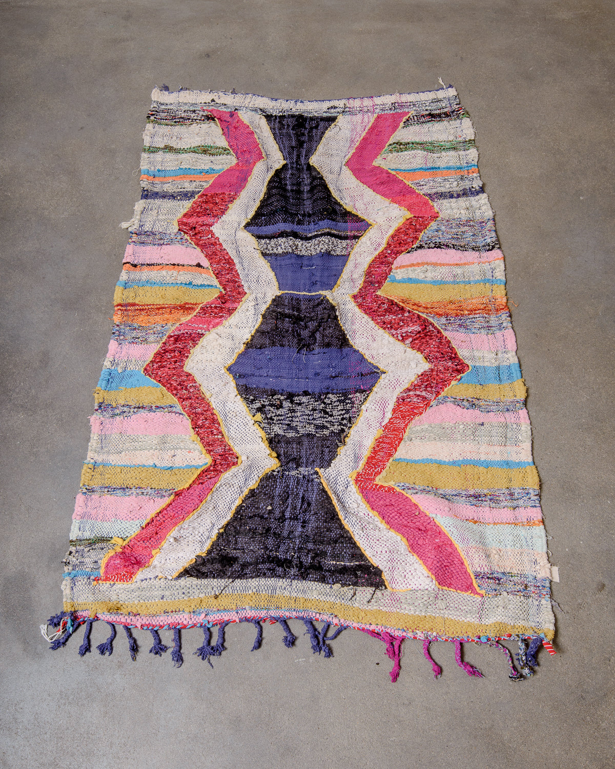 Berberlin vintage kelim rug made of recycled materials laying flat on a concrete floor.